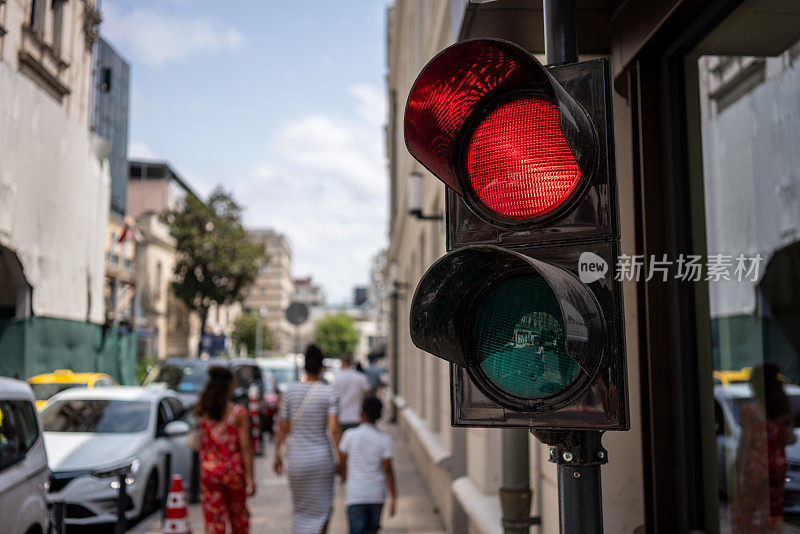 行人交通灯集中在前景街道上，行人仍然是背景水平行进