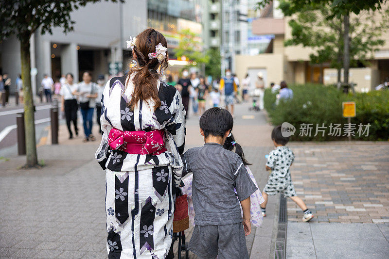 夏季节日时一家人在汤田走在街上的后景