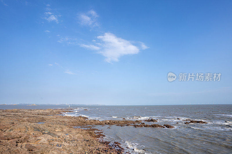 在晴朗的日子里，海边的礁石和海浪