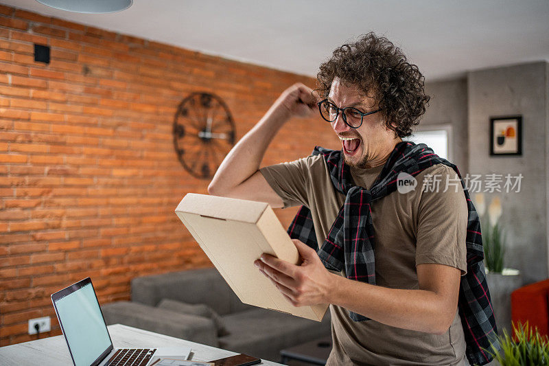 一名开心的白人男子刚刚收到了他在网上订购的包裹