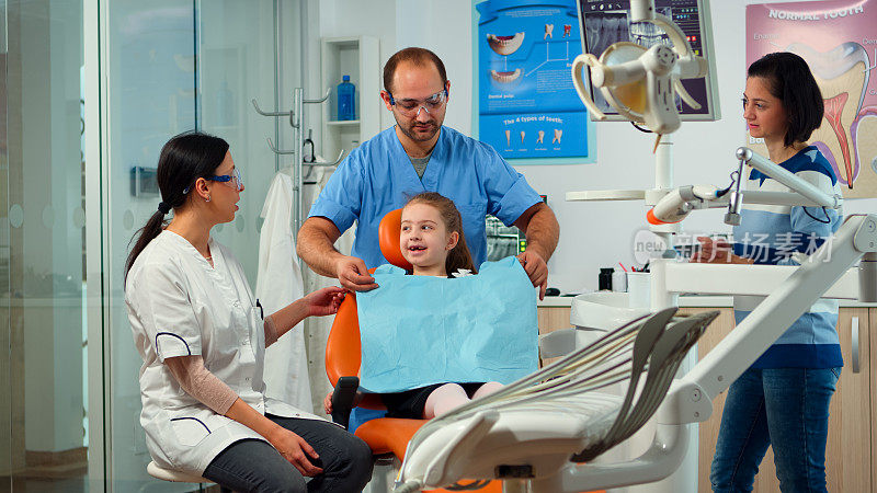 患有牙痛的小女孩向儿科牙医解释牙齿问题