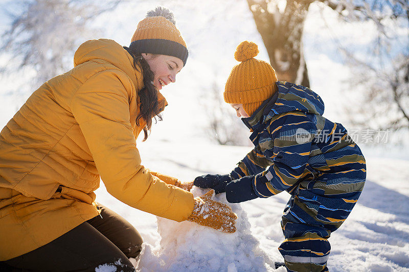 妈妈和儿子一起堆雪人