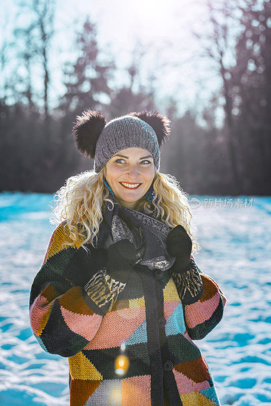 幸福的女人在冬天森林附近的白雪皑皑的草地