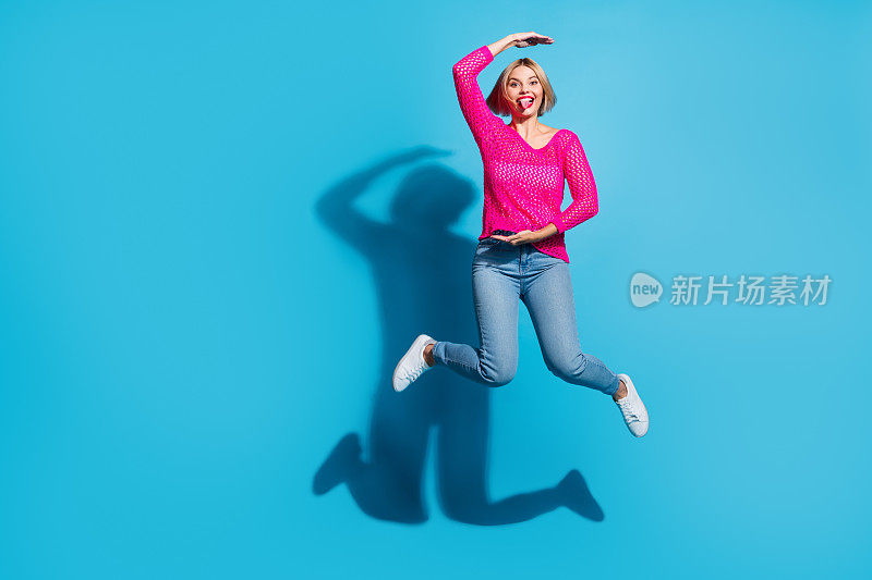 迷人的年轻女子的全身照片跳跃显示尺寸尺寸穿着时尚的粉红色针织衣服孤立的蓝色背景