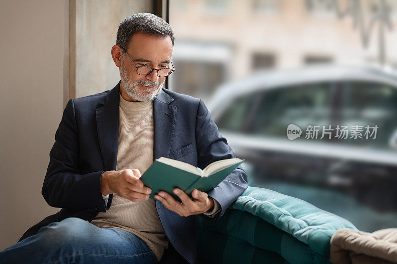 一位深思熟虑的老人，戴着眼镜，舒舒服服地坐着，全神贯注地看书