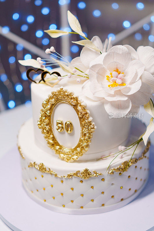 美丽的白色双层蛋糕，上面装饰着鲜花。50周年纪念蛋糕。