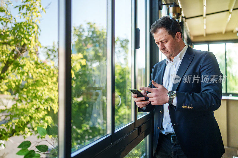 一个系列的一部分:商人在窗前使用手机。