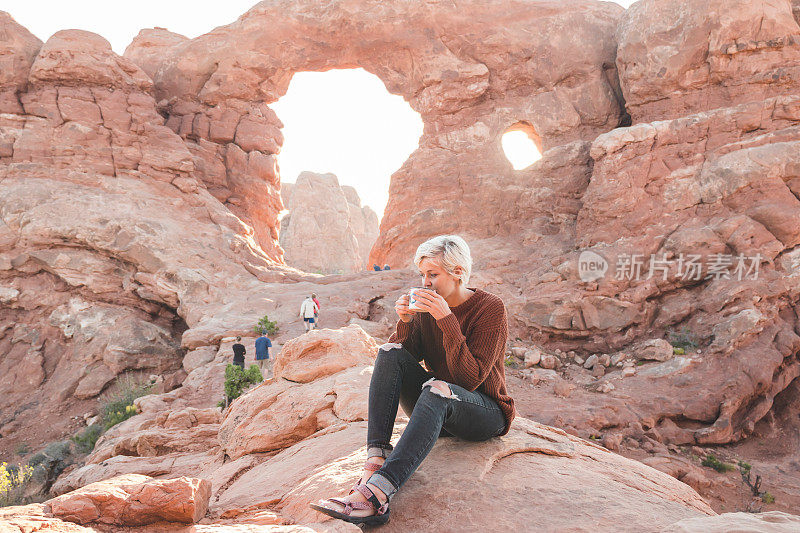 女性徒步旅行者享受一杯早晨的咖啡在沙漠徒步旅行