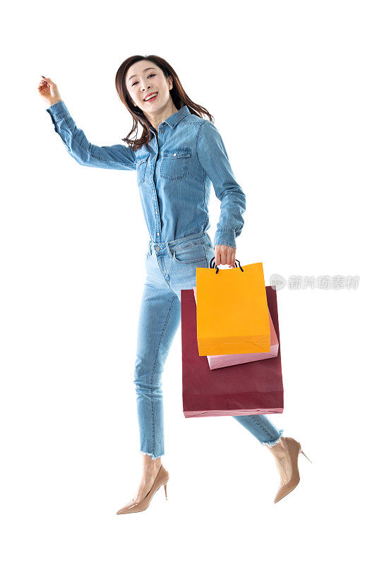 快乐的女人拿着购物袋在白色的背景
