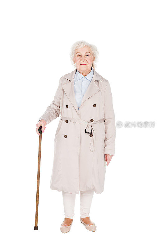 高高兴兴的老妇人拄着拐杖孤立地站在白色的地上