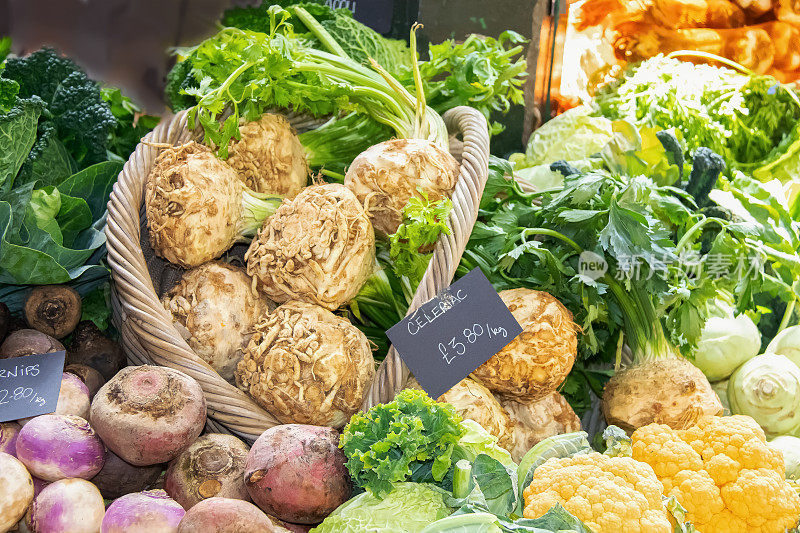 英国市场的篮子和成堆的蔬菜，包括萝卜、羽衣甘蓝、块根芹和花椰菜