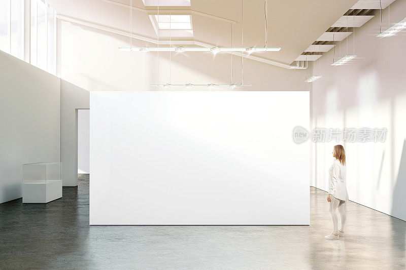女人走在现代画廊的空白白墙模型附近