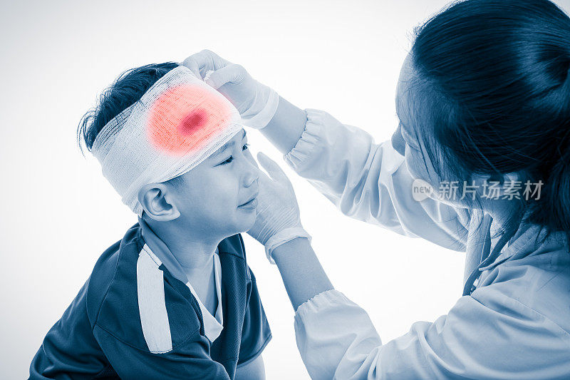 运动损伤。医生给病人头上缠了绷带。