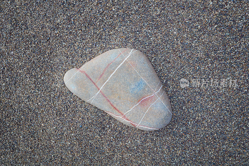 设计组成卵石在深棕色的沙子背景上