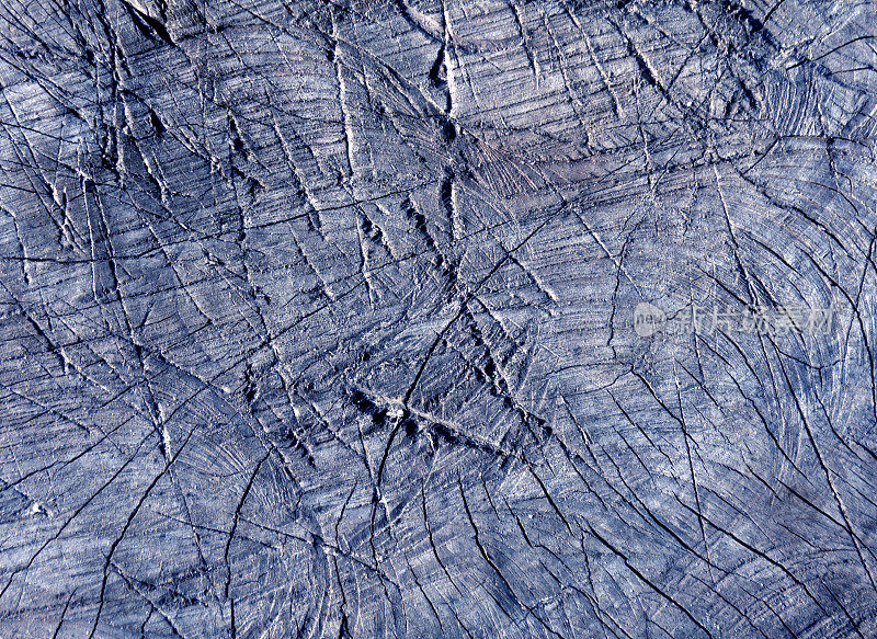 抽象的蓝色色调的老树表面用斧头划痕。
