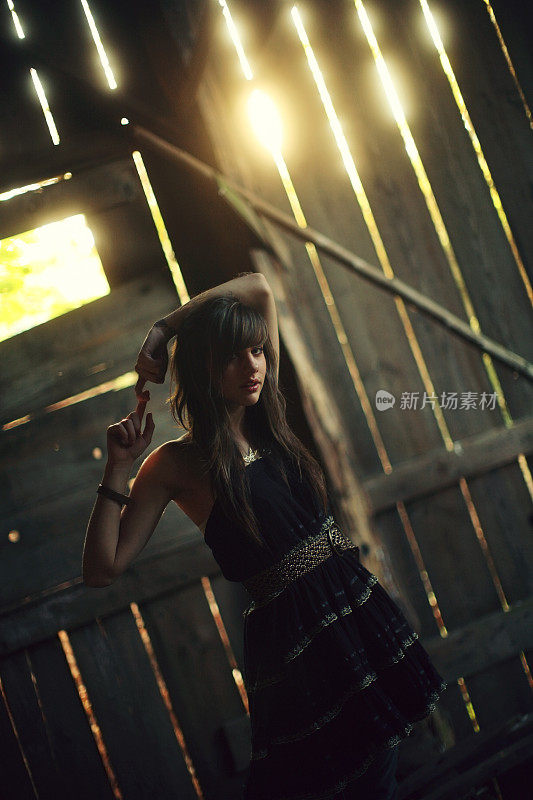 少女与黑色连衣裙在木棚日落