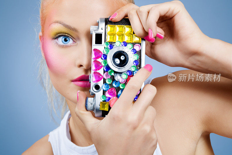年轻女子摆姿势与宝石古董相机