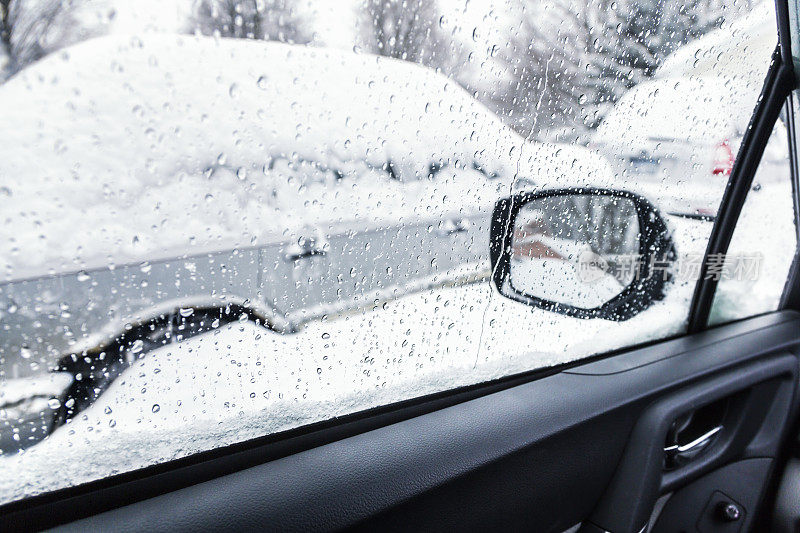 融化的冬季雪水滴透过车窗