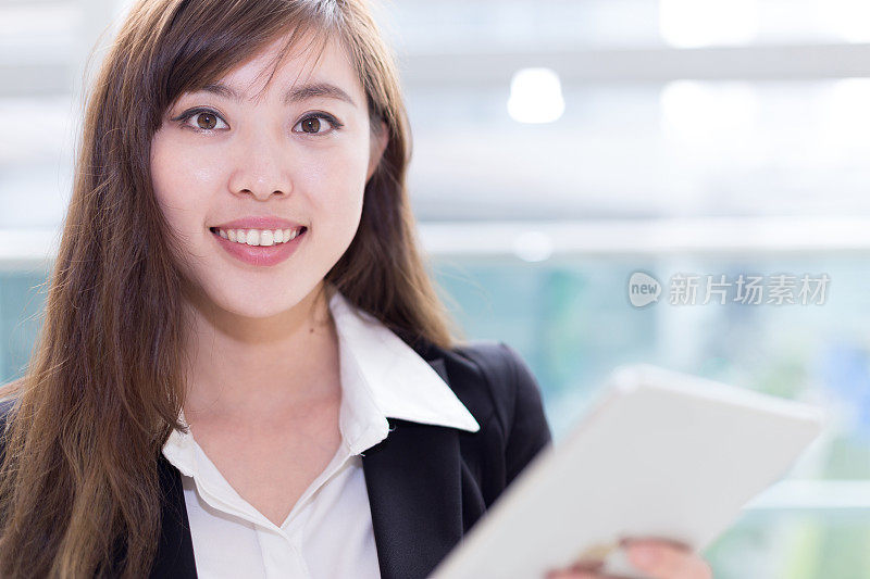亚洲成功女商人在办公室走廊使用平板电脑