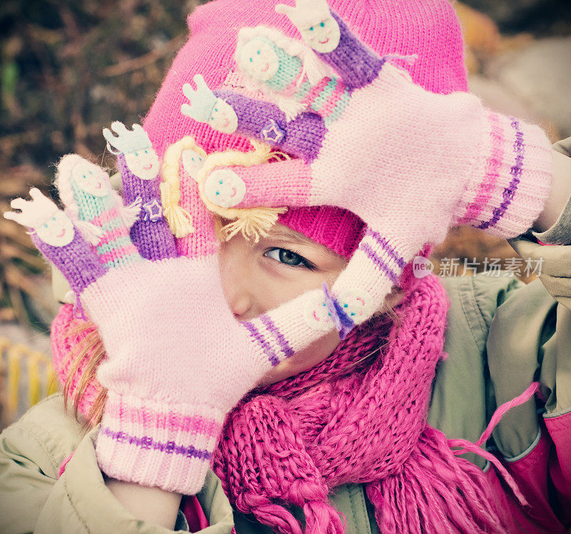 小女孩穿着冬装在户外玩耍