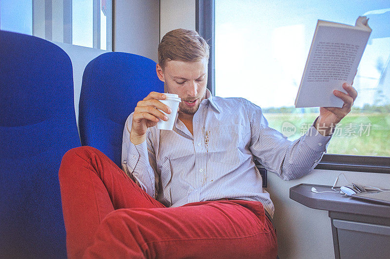 年轻英俊的男人在火车上洒了咖啡在衬衫上