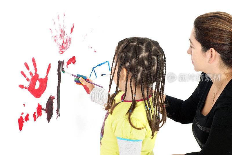 小女孩正在和她的妈妈一起画画