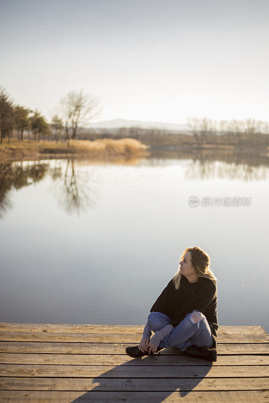 年轻女子在湖边休息