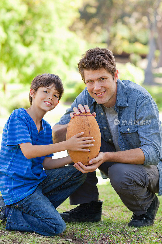 父亲和儿子在公园与足球的特写