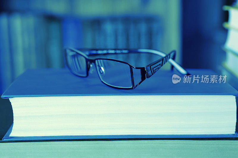 阅读概念-一本书上的眼镜