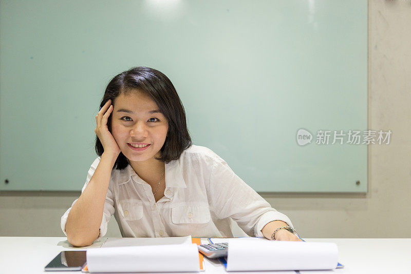 微笑的亚洲员工对她的日常工作感到高兴