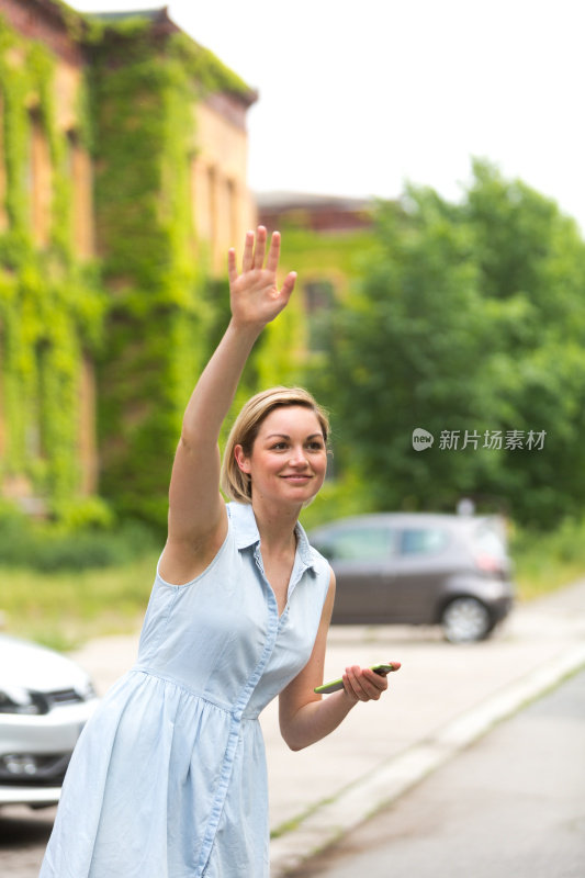 年轻女子拿着手机找出租车