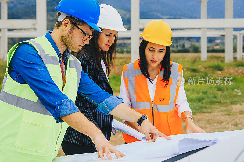 建筑工人和建筑师在建筑工地看设计图