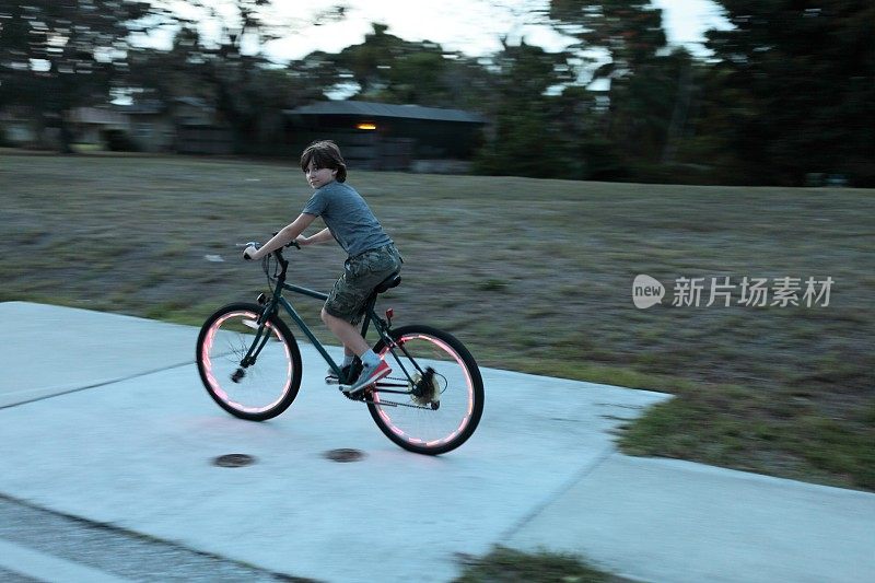 男孩骑自行车。自行车红灯。