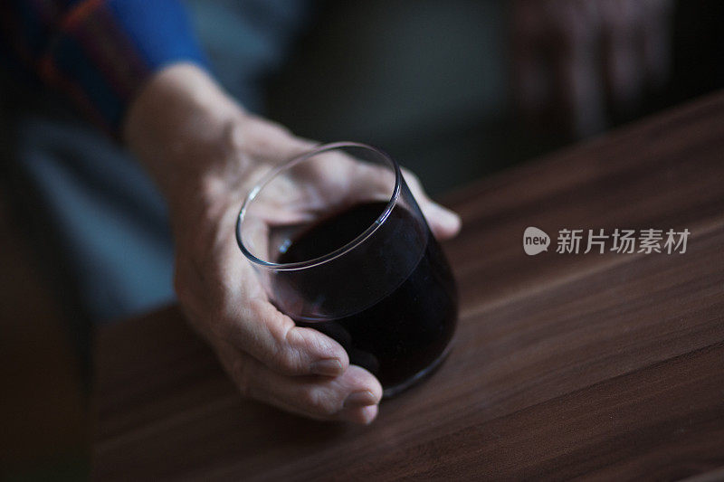 老人拿着一杯酒——靠近