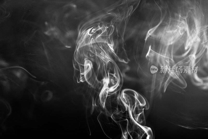 黑色和白色的旋转烟雾抽象的接近黑色的背景