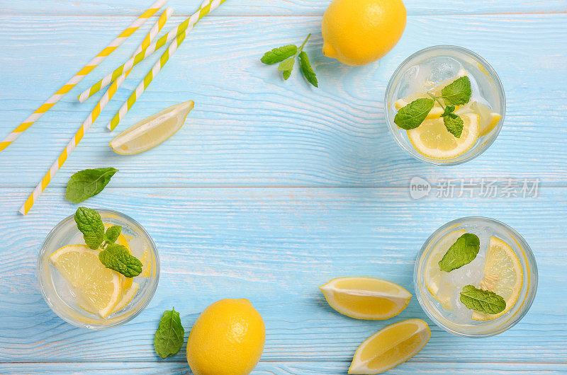 清凉的夏日饮品，柠檬和薄荷，浅蓝色的木质背景。