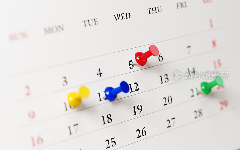 白色日历与彩色图钉显示重要日期