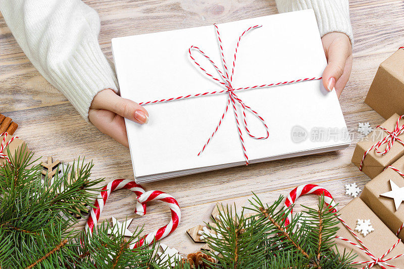 那个女孩拿着孩子们的圣诞信。圣诞信件与礼物盒和圣诞装饰