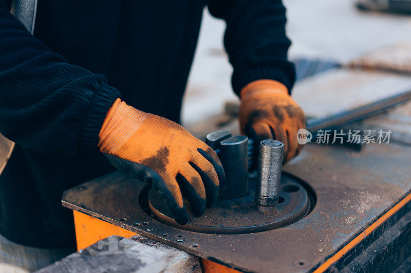 建筑工人在施工现场使用工业机械作弯曲夹钳