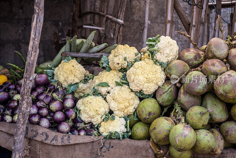 大量的菜花，茄子和椰子从街头市场