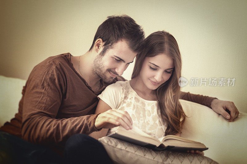 年轻夫妇在读一本书