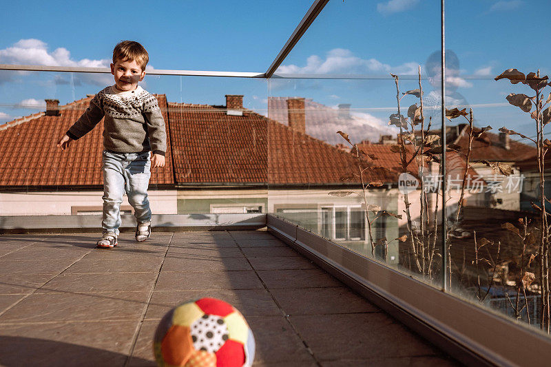 男孩在阳台上玩球