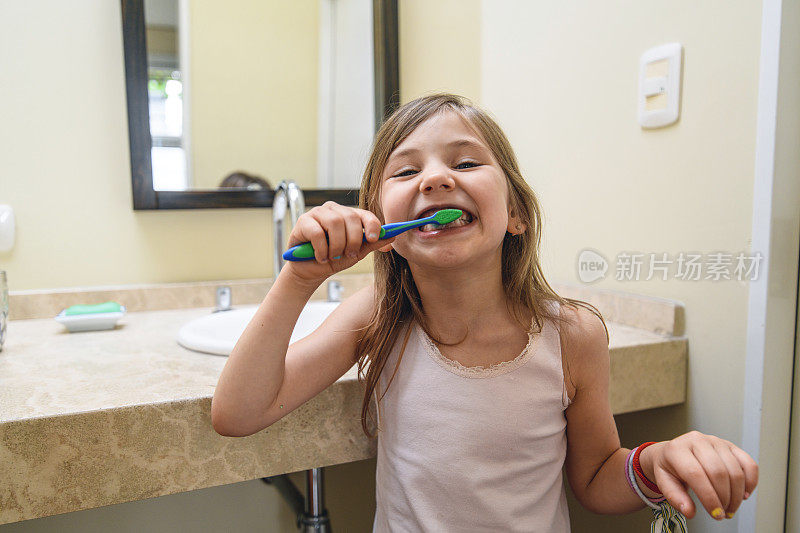 顽皮的小女孩在家里的浴室里刷牙