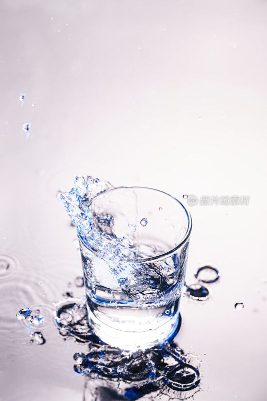 纯净水从玻璃杯里飞溅出来