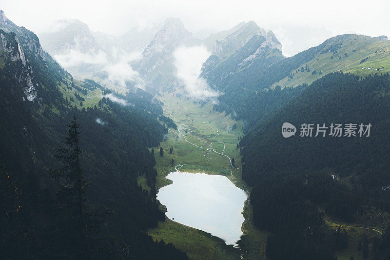 在瑞士阿尔卑斯山的夏季雨天，绿松石湖和山被雾覆盖的戏剧性景色