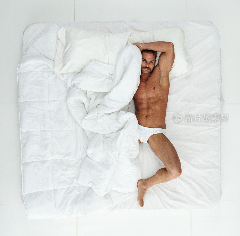 男性放松在卧室的白色背景下穿着赛车内裤