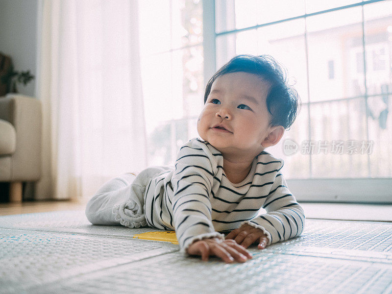 小男孩在垫子上笑着。