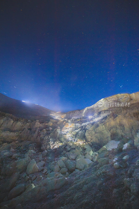 硫磺湖和冒烟的矿山山早上在卡瓦伊真火山印度尼西亚东爪哇与银河夜空的背景