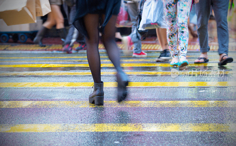 香港，妇女过马路。雨湿斑马线