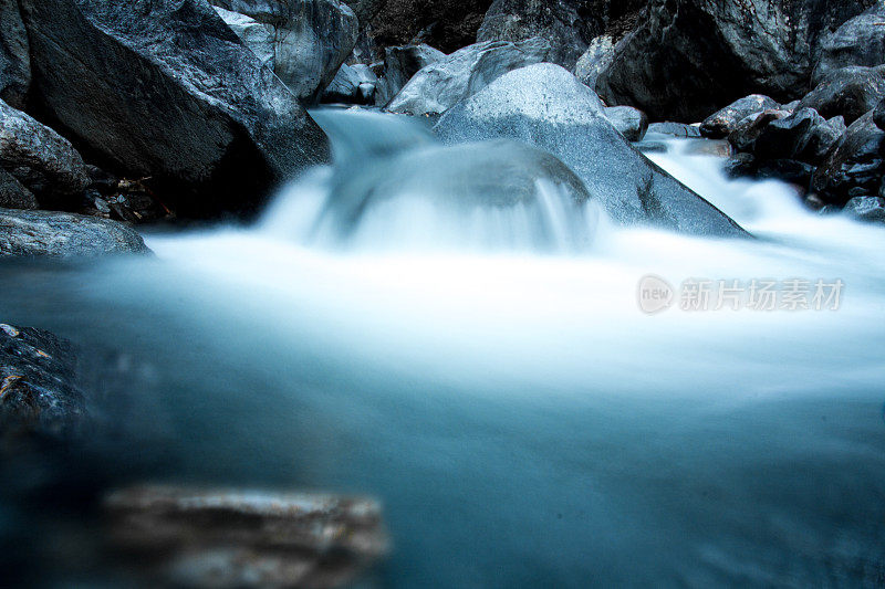 高山溪流在崎岖的环境中流过绿色的岩石